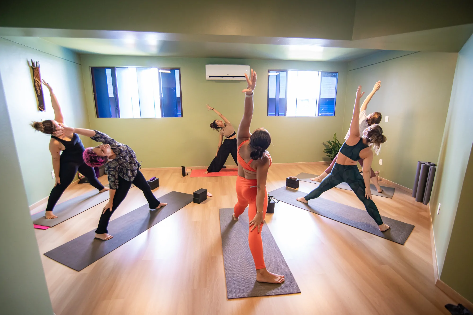 turmas presenciais - Fusão Yoga Studio - professora e alunas na postura guerreiro reverso